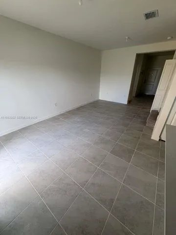 a view of a room with wooden floor and cabinets