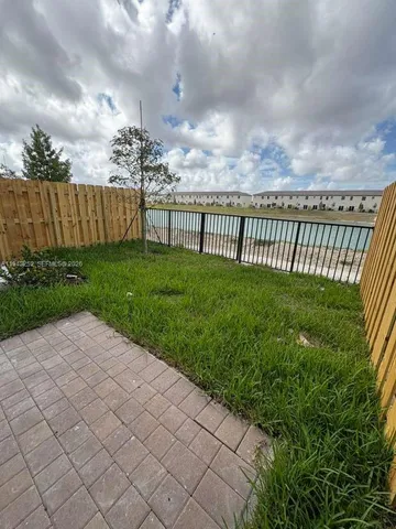 a view of a backyard with wooden fence