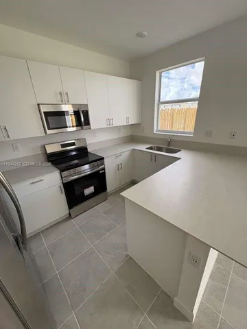 a kitchen with a stove a sink and a microwave