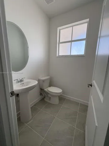 a bathroom with a sink toilet and window
