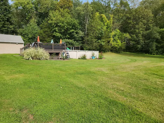 a backyard of a house with table and chairs