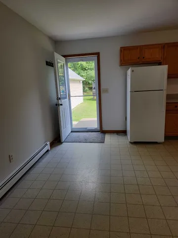 a view of an empty room with a fireplace and a window