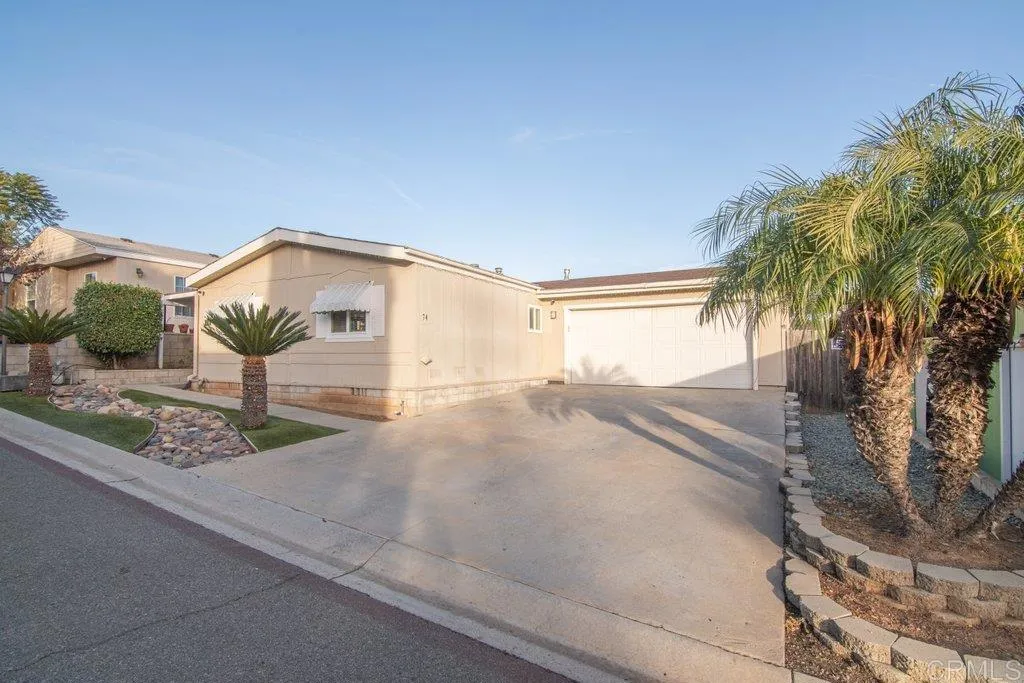 a view of a house with a yard and potted plants