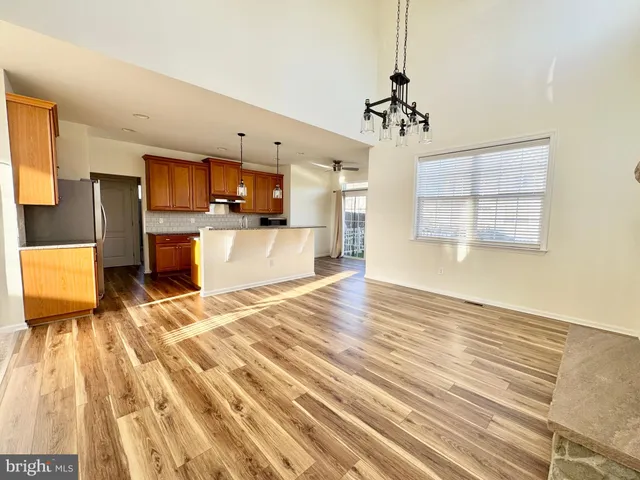 a view of a kitchen with kitchen island wooden floor center island and stainless steel appliances