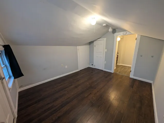 an empty room with wooden floor and mirror