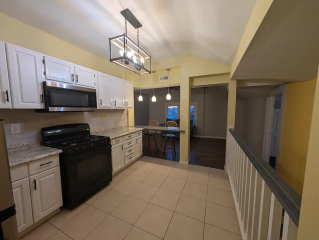 a kitchen with a stove cabinets and a refrigerator