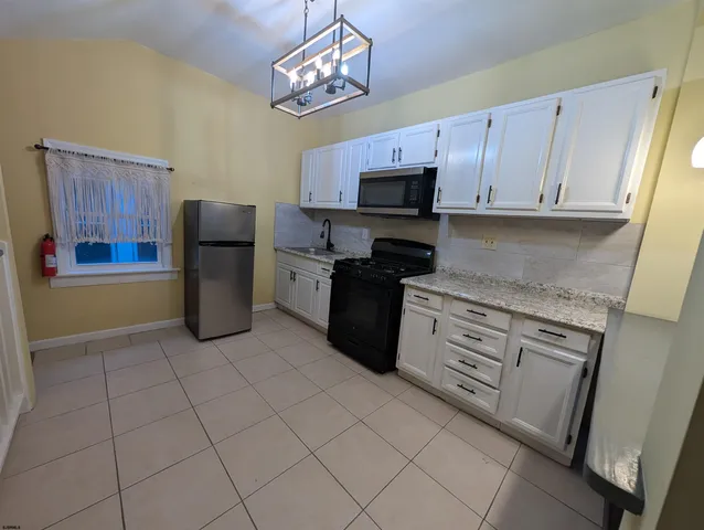 a kitchen with stainless steel appliances granite countertop a refrigerator stove a sink and dishwasher