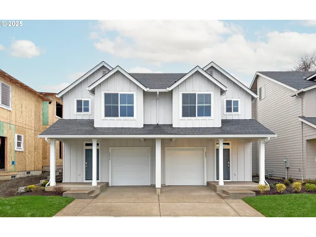 a front view of a house with yard and parking