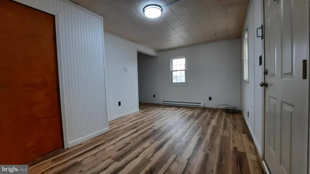 a view of a room with wooden floor and window
