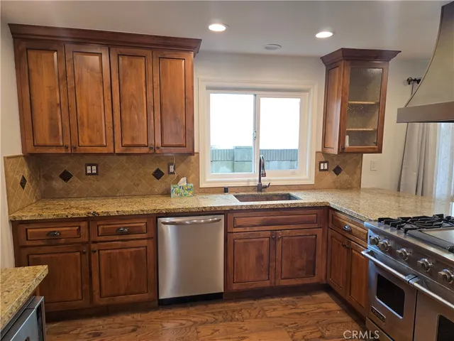 a kitchen with stainless steel appliances granite countertop a stove a sink and a microwave