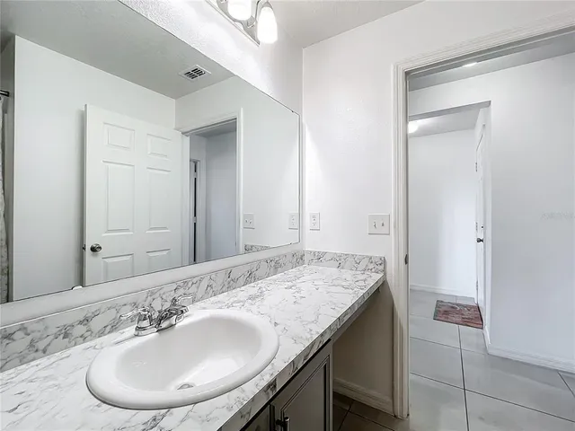 a bathroom with a granite countertop sink and a mirror