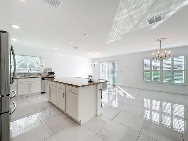 a kitchen with white cabinets and window