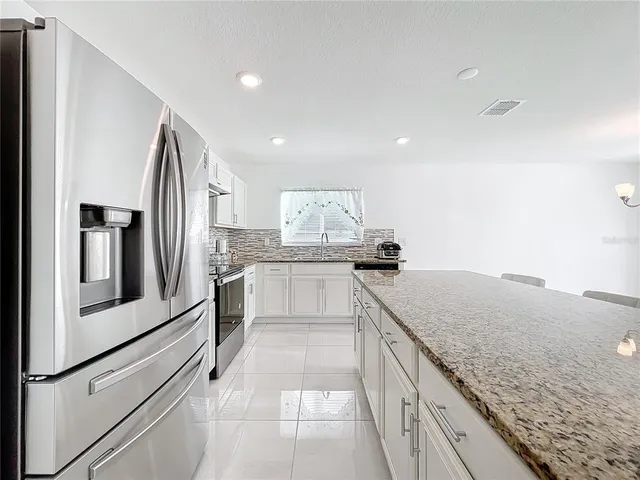 a kitchen with stainless steel appliances granite countertop a sink and dishwasher a stove with wooden floor
