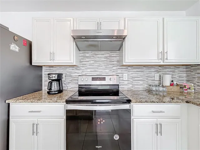 a kitchen with granite countertop cabinets stainless steel appliances and a sink