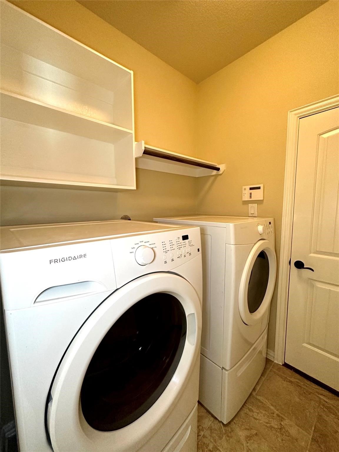 14818 Raleigh's Meadow Court Cypress, TX 77433 - Photo 13 of 17 a close view of a utility room with dryer and washer