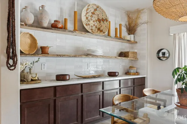 a kitchen with stainless steel appliances kitchen island granite countertop a table chairs and a refrigerator