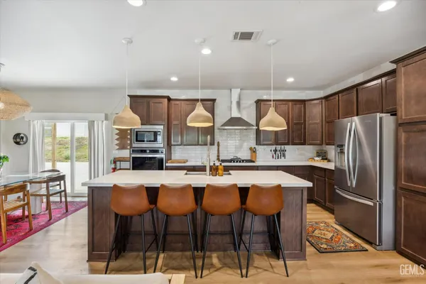 a kitchen with stainless steel appliances granite countertop a sink stove and cabinets