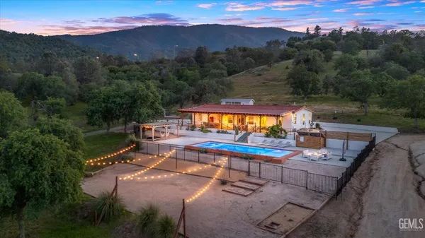 an aerial view of residential houses with outdoor space and trees