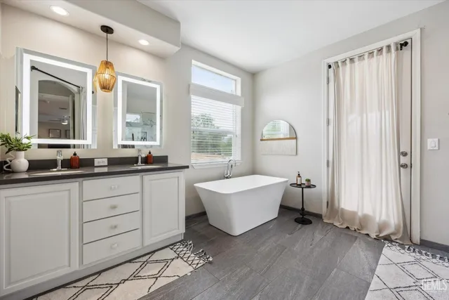 a spacious bathroom with a sink a mirror and a bathtub