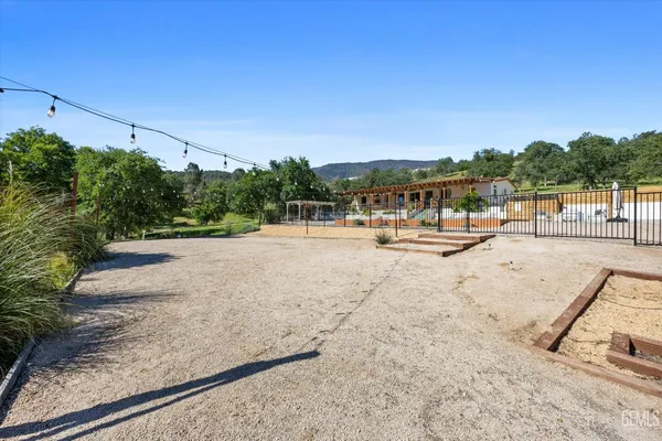 an aerial view of residential houses with outdoor space and trees