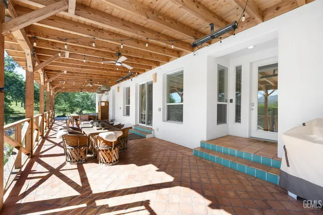 a living room with furniture kitchen view and a large window
