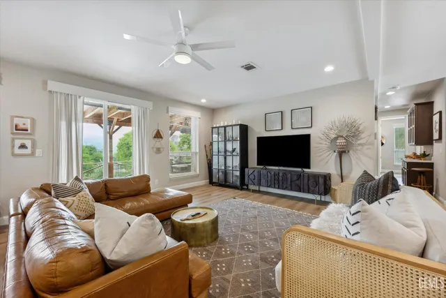 a living room with furniture kitchen view and a flat screen tv