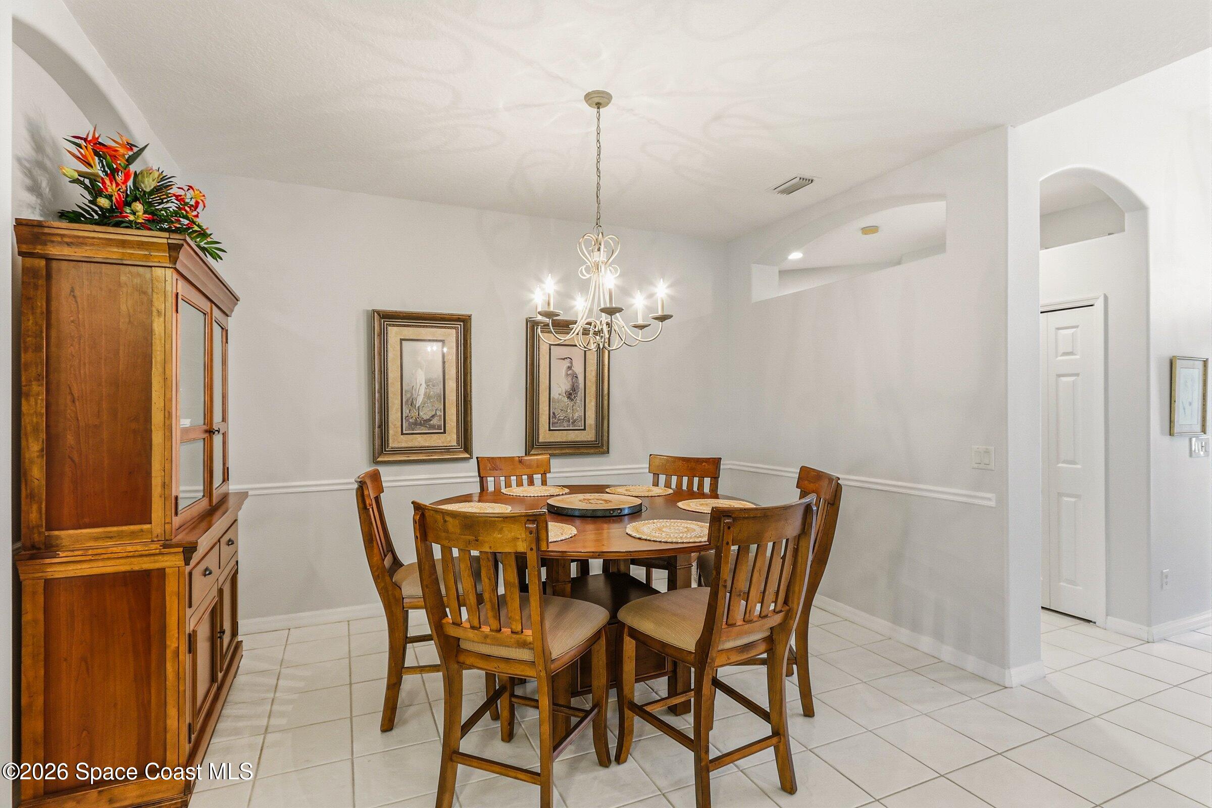 1825 Ficus Point Drive Melbourne, FL 32940 - Photo 12 of 48 a view of a dining room with furniture a chandelier and wooden floor