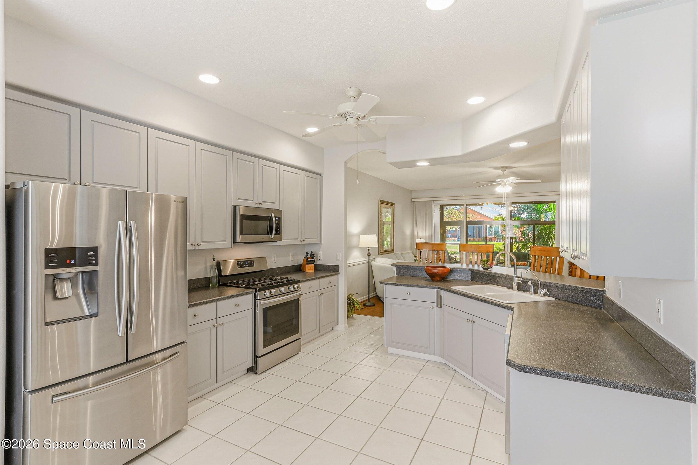 1825 Ficus Point Drive Melbourne, FL 32940 - Photo 15 of 48 a kitchen with white cabinets and stainless steel appliances
