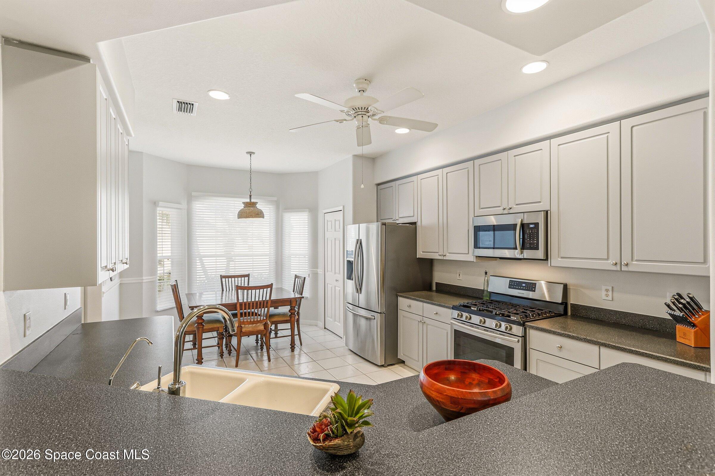 1825 Ficus Point Drive Melbourne, FL 32940 - Photo 17 of 48 a kitchen with stainless steel appliances kitchen island granite countertop a stove refrigerator and cabinets
