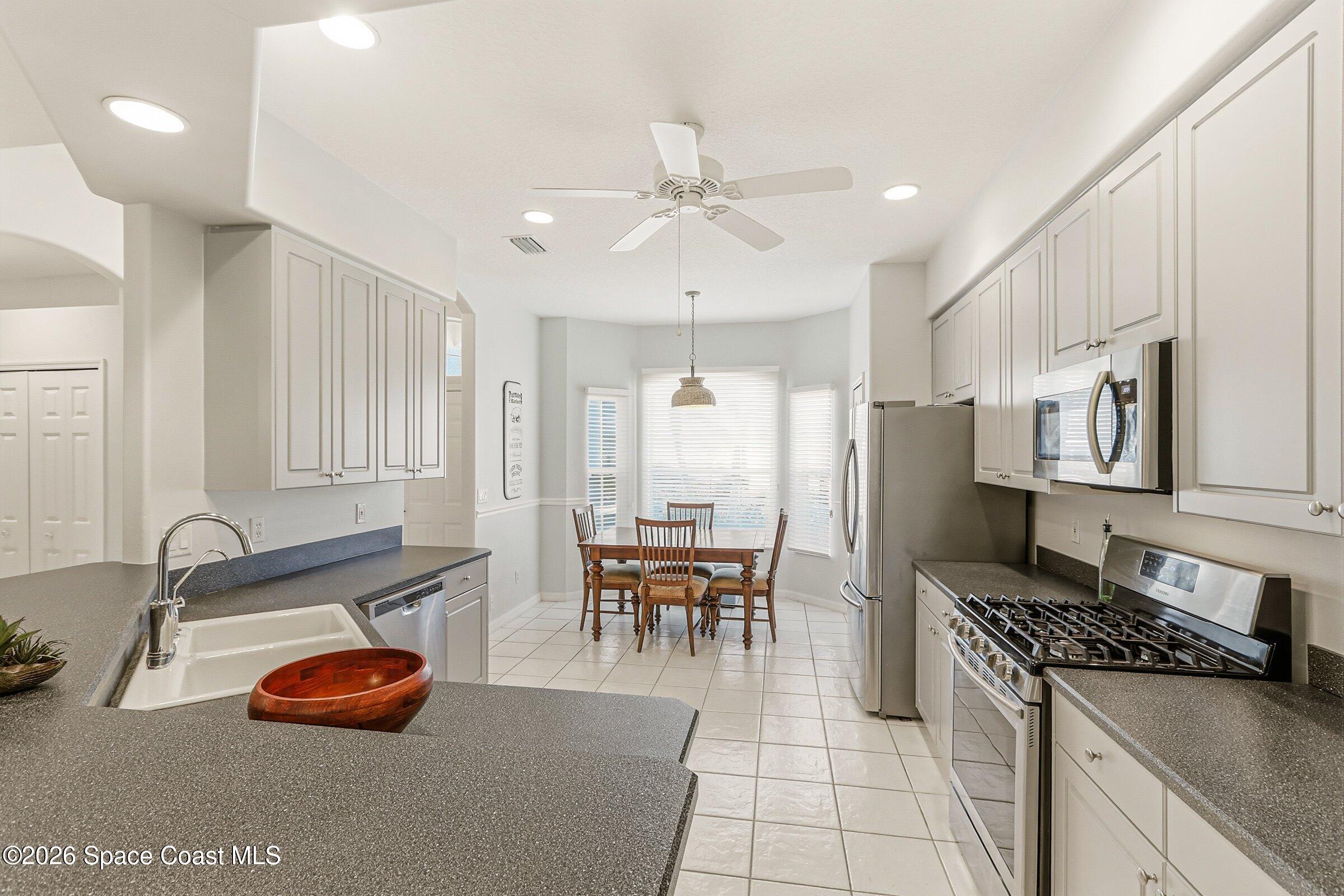 1825 Ficus Point Drive Melbourne, FL 32940 - Photo 19 of 48 a kitchen with stainless steel appliances granite countertop a stove a sink and a refrigerator