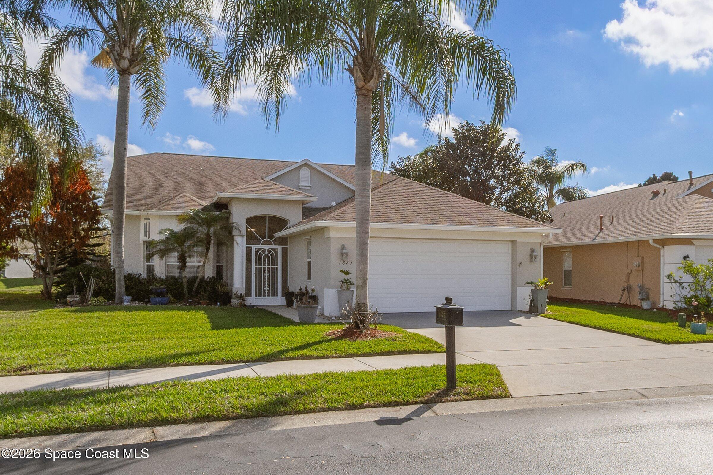 1825 Ficus Point Drive Melbourne, FL 32940 - Photo 6 of 48 a front view of a house with a garden and tree