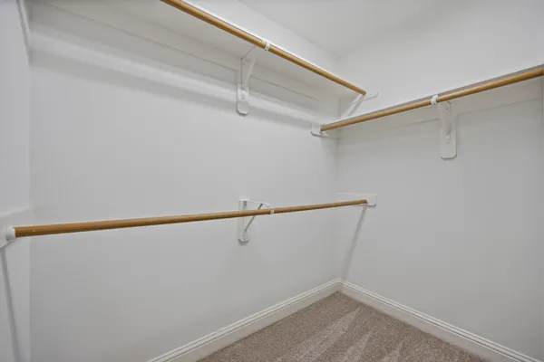 an empty room with a chandelier fan and windows