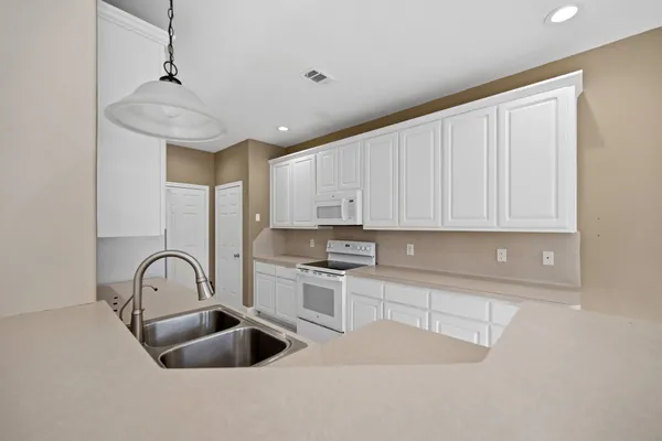 a kitchen with a sink appliances and cabinets