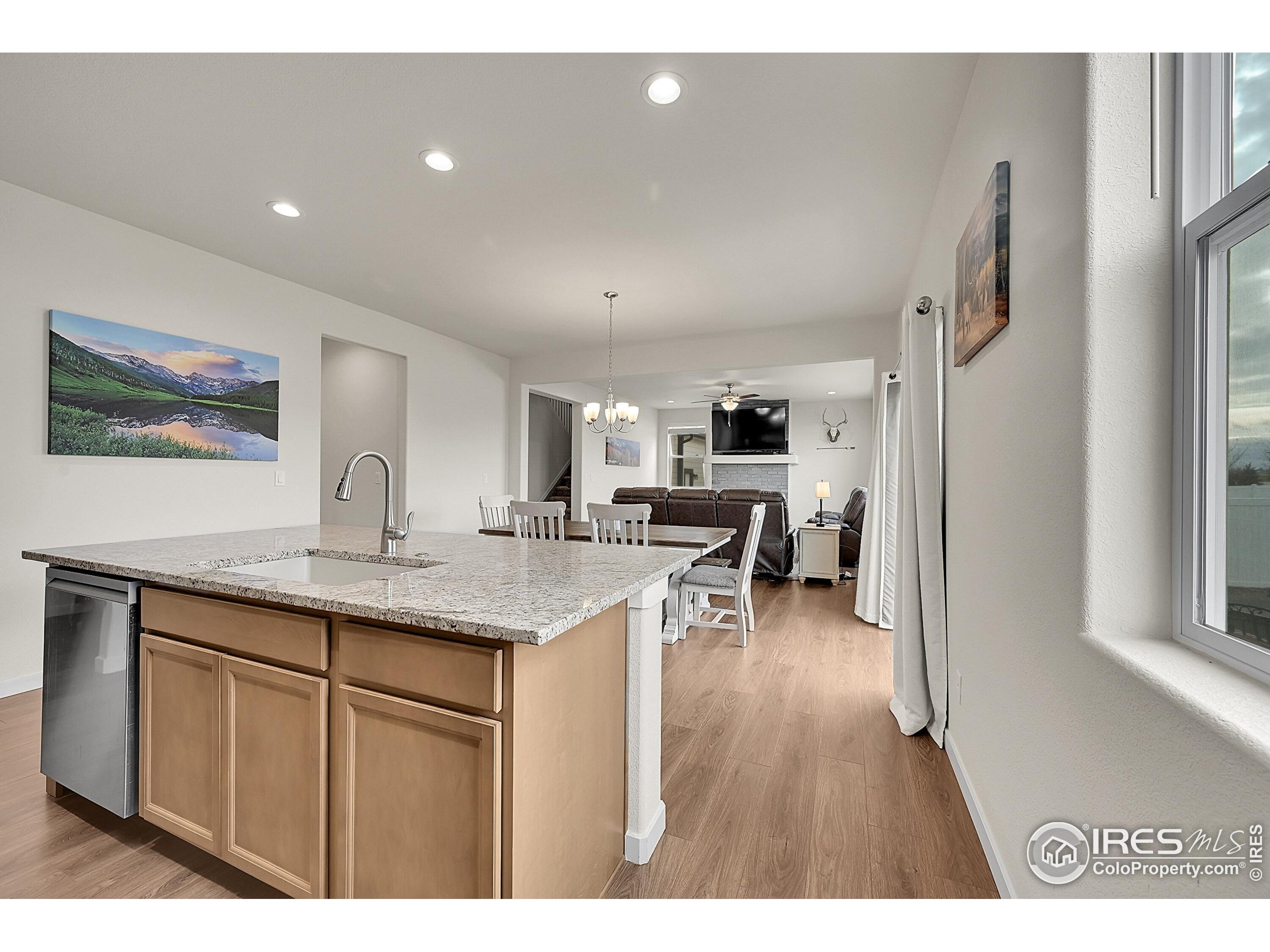 2538 Doe Rdg Way Johnstown, CO 80534 - Photo 11 of 33 a open kitchen with stainless steel appliances granite countertop a refrigerator a sink dishwasher and a dining table with wooden floor