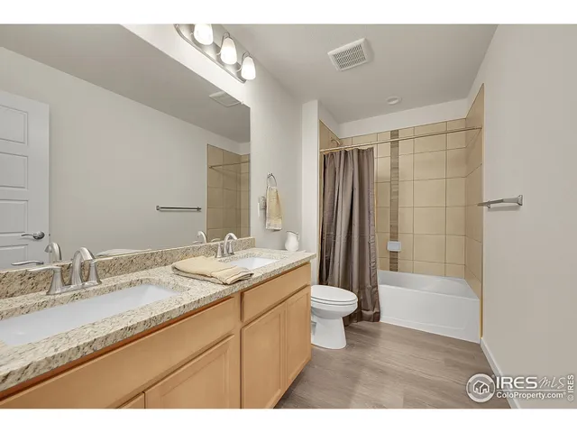 a bathroom with a granite countertop sink toilet a large mirror a bathtub and shower