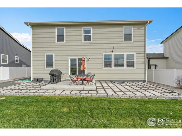 a view of a backyard with table and chairs and wooden fence
