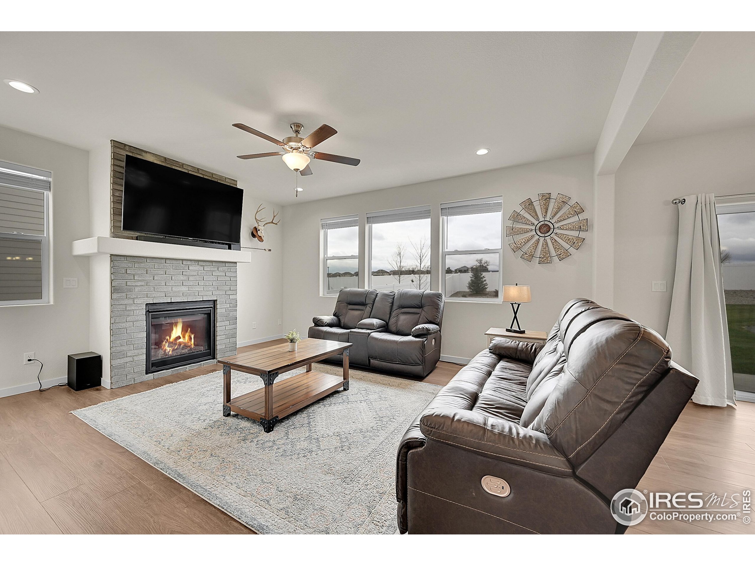 2538 Doe Rdg Way Johnstown, CO 80534 - Photo 5 of 33 a living room with furniture a flat screen tv and a fireplace