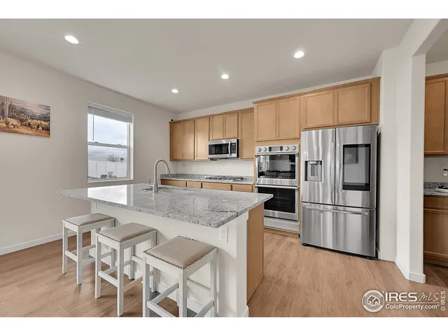 a kitchen with stainless steel appliances granite countertop a refrigerator and a stove top oven