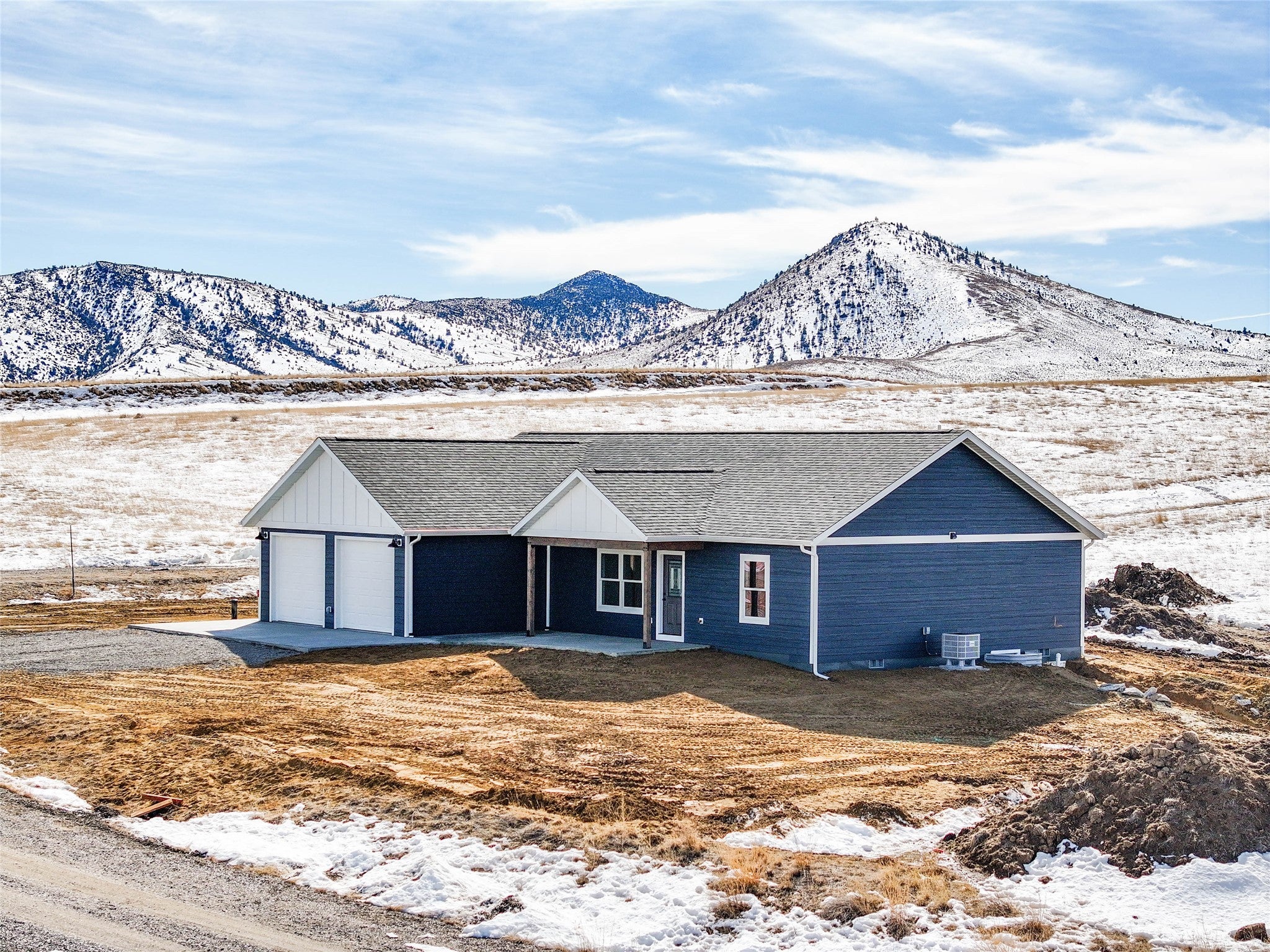 24 Durango Trail Three Forks, MT 59752 - Photo 1 of 1 View of front of property with cooling unit, driveway, a shingled roof, board and batten siding, and a mountain view