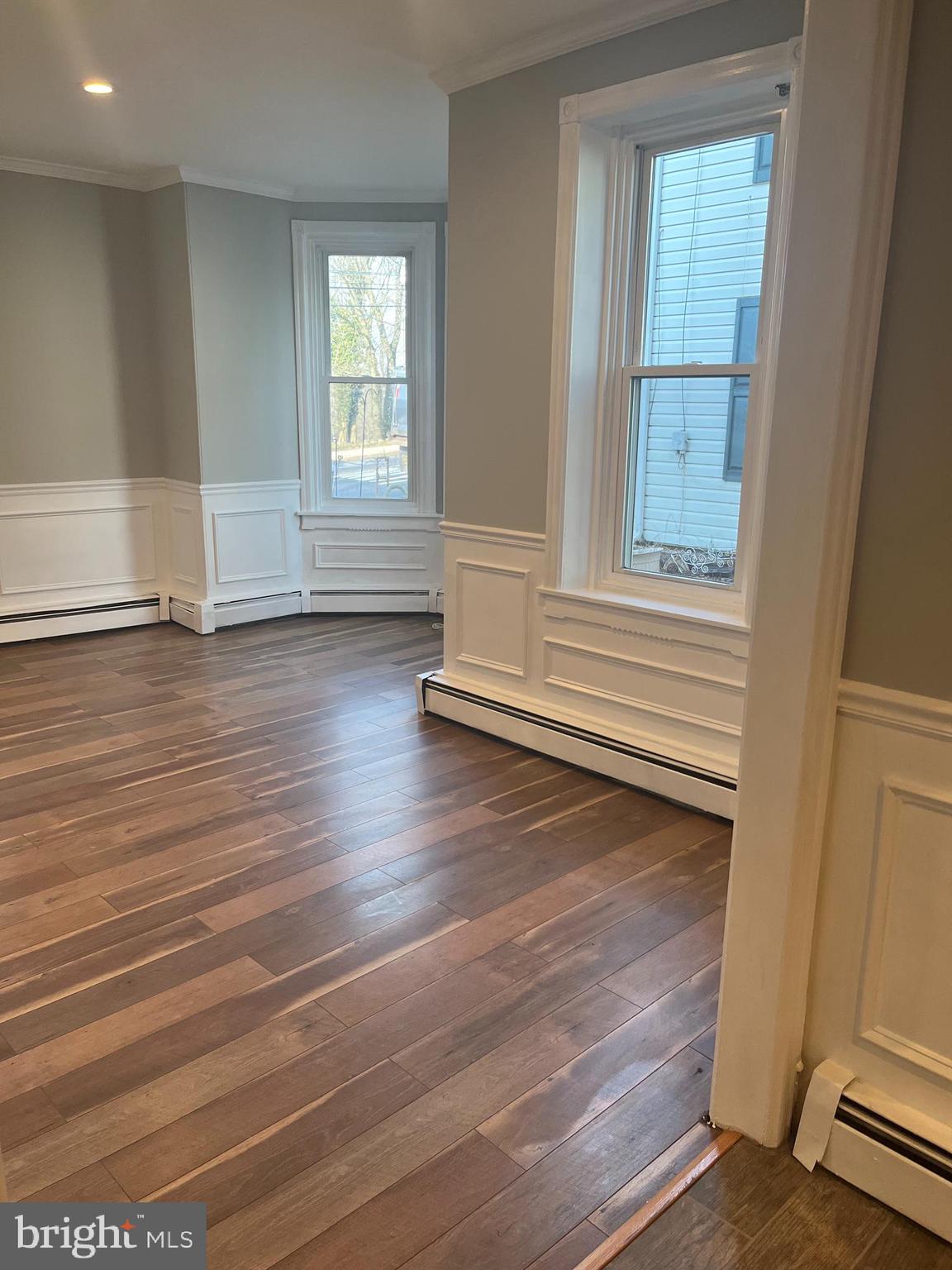 55 North Main Street Chalfont, PA 18914 - Photo 11 of 15 an empty room with wooden floor and windows