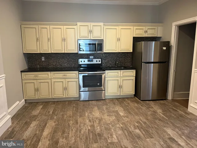 a kitchen with a refrigerator sink and cabinets