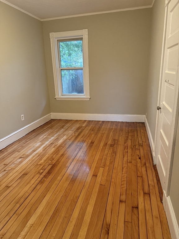 395 Talbot Avenue, Unit 1 Boston, MA 02124 - Photo 3 of 7 a view of an empty room with wooden floor and a window