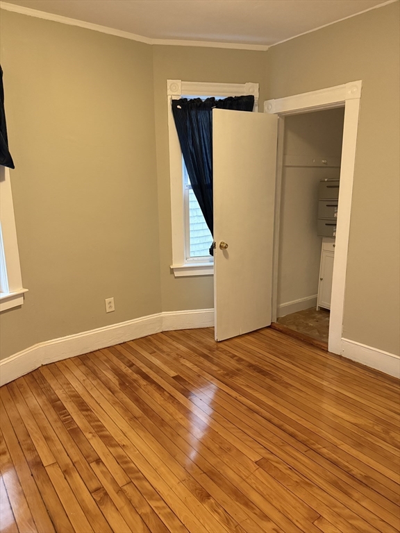 395 Talbot Avenue, Unit 1 Boston, MA 02124 - Photo 7 of 7 a view of an empty room with wooden floor and a window