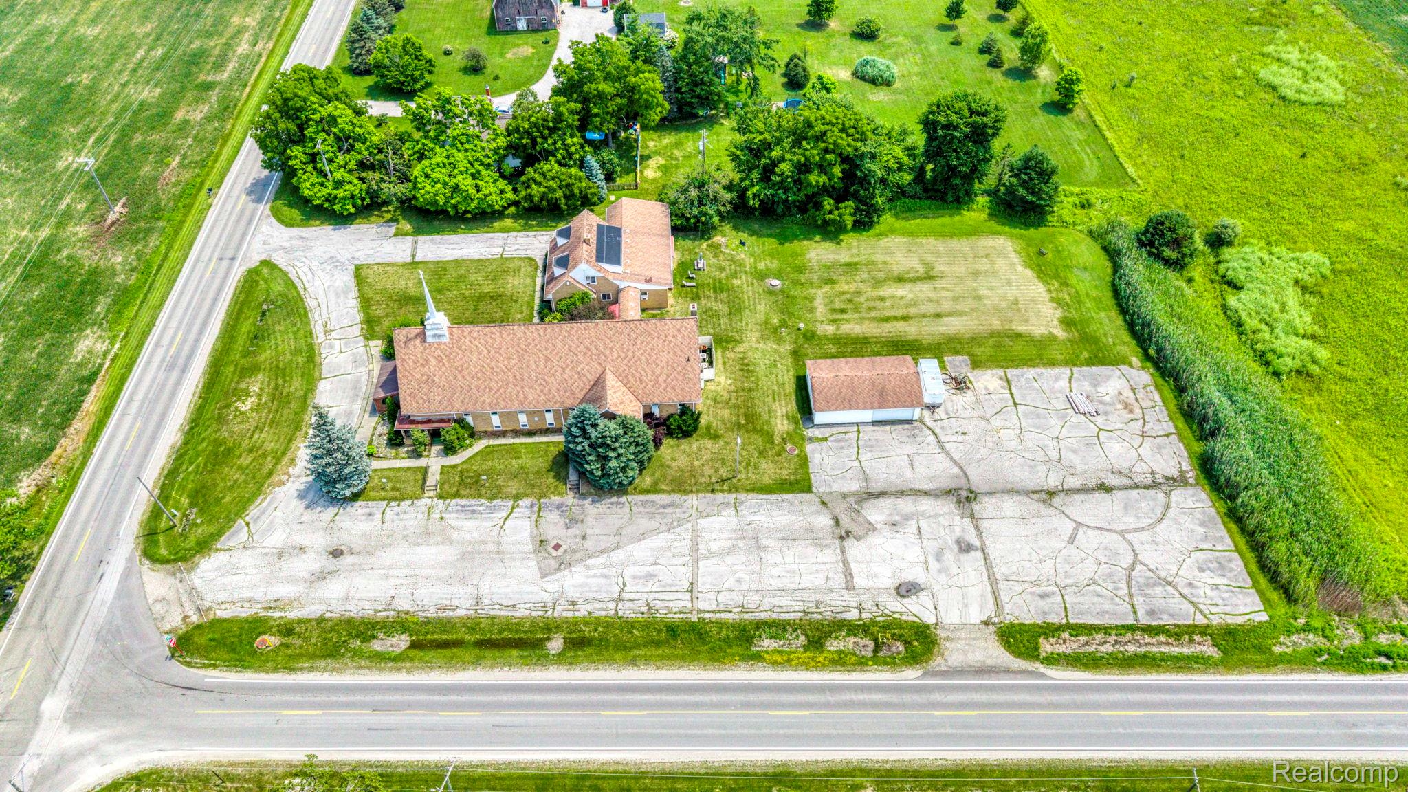 9735 Dolan Road Columbus, MI 48063 - Photo 12 of 63 Expansive property featuring a large main building with a shingle roof and a secondary structure