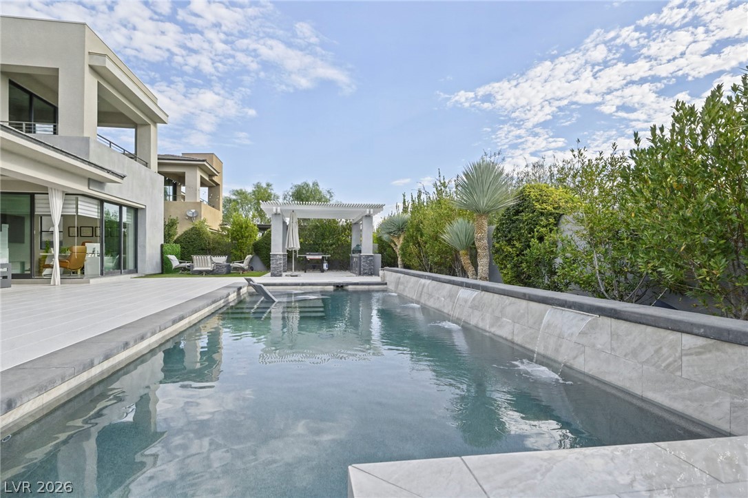 4208 Lapis Ridge Court Las Vegas, NV 89135 - Photo 44 of 61 A pristine rectangular swimming pool highlights the modern stone terrace and sleek outdoor living space.