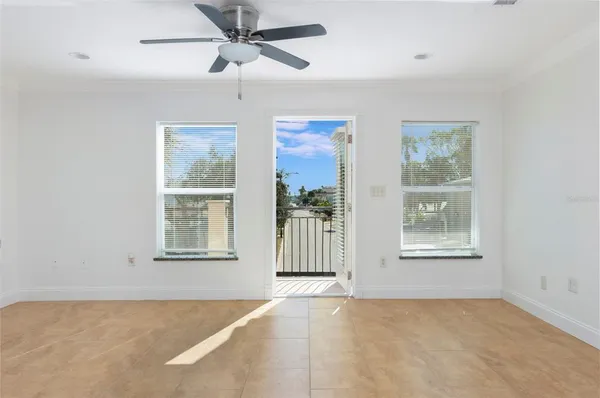 an empty room with windows and fan
