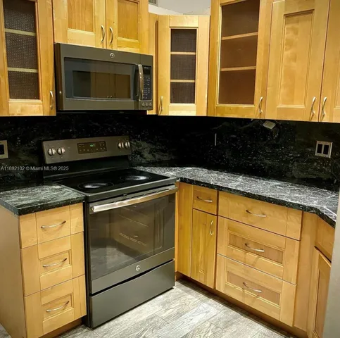 a kitchen with granite countertop white cabinets and black appliances