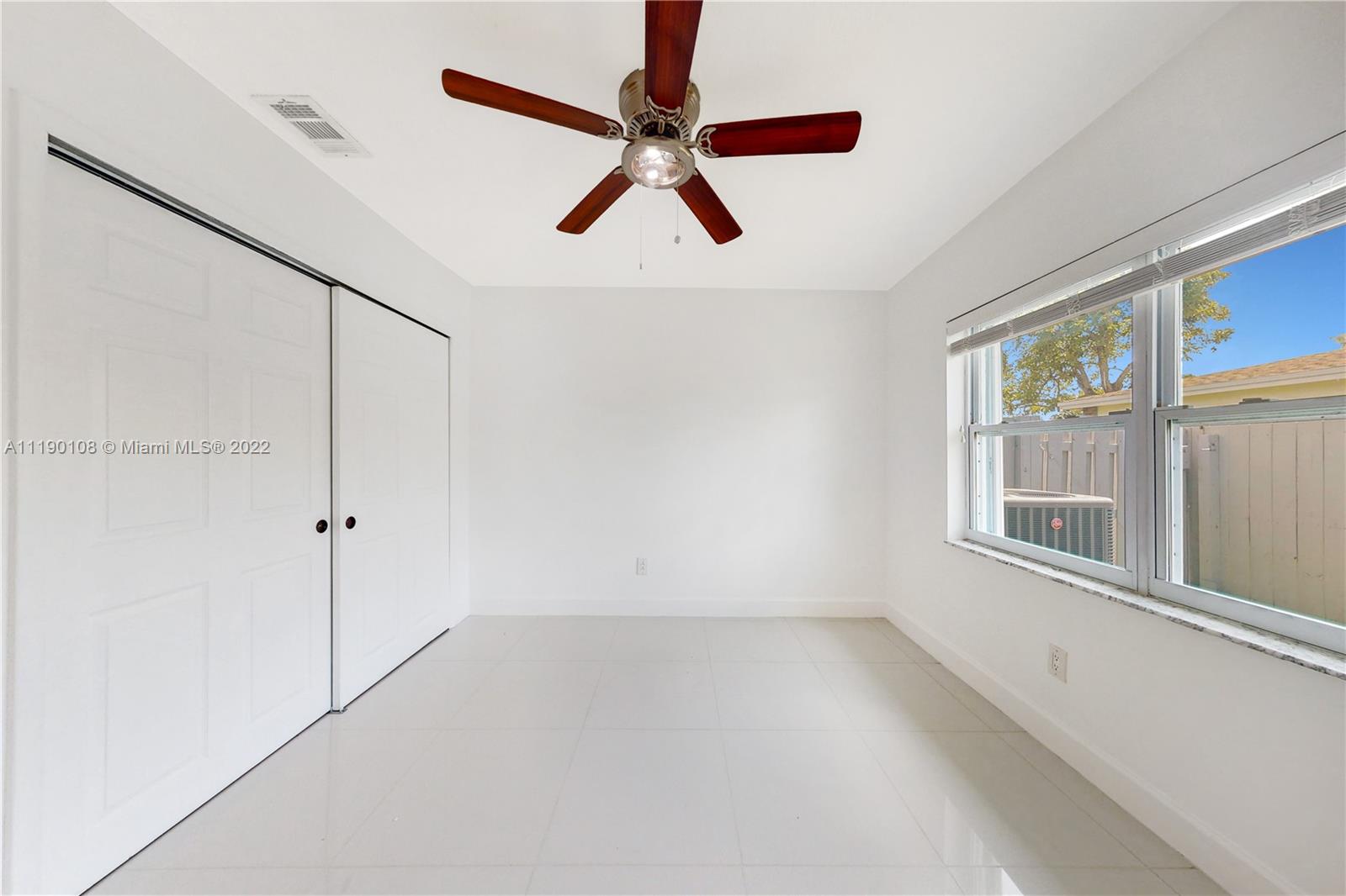 4641 Armadillo Street Boca Raton, FL 33428 - Photo 17 of 60 an empty room with windows and fan
