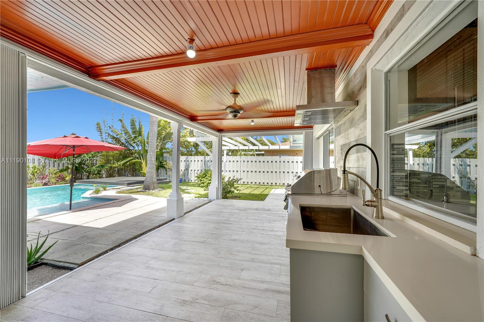 4641 Armadillo Street Boca Raton, FL 33428 - Photo 33 of 60 a view of a patio with a table and chairs under an umbrella