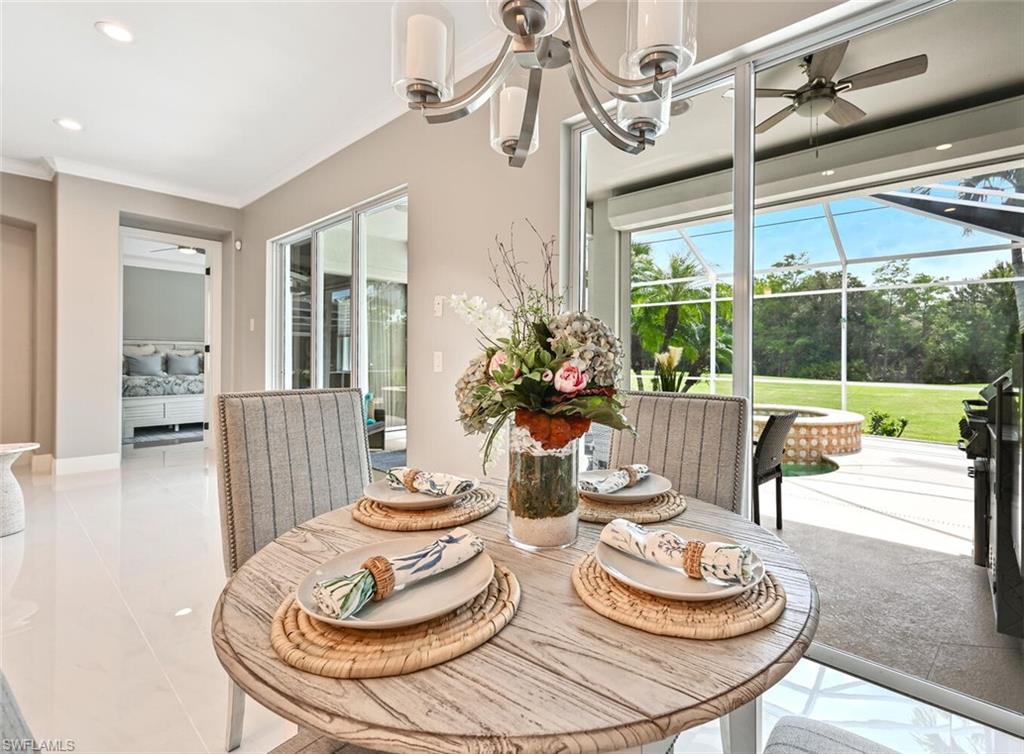 5616 Lago Villaggio Way Naples, FL 34104 - Photo 14 of 43 a dining room with furniture a chandelier and wooden floor